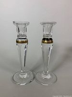 Front view of both candleholders showing faceted stems and round bases