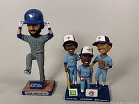 Photo shows all four Toronto Blue Jays bobbleheads together: Jose Bautista in gray uniform and trio set of George Bell, Lloyd Moseby, and Jesse Barfield in blue uniforms.