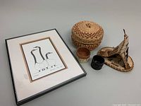 Overall view of the framed print with title 'Friends' by Benjamin Chee Chee alongside various vintage Indigenous handcrafted items including a birch bark teepee sculpture, a woven basket, and three small containers.