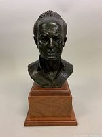 Front view of bronze bust on wooden base