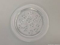 Top view showing entire round crystal plate with raised flower design.