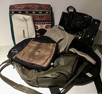 Overall view of seven assorted bags including a crochet bag, the Harrods bag, the Timbuk2 saddle bag, and others grouped together