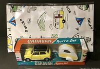 Full boxed set showing packaging with the yellow Mini Cooper and white and yellow teardrop trailer.