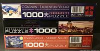 Stacked view of three Eurographics 1000-piece puzzle boxes showing artwork, puzzle piece count, and branding.