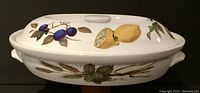 Side view of the lidded dish showing fruit illustrations (plums and lemon)