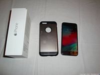 Photo of iPhone 6, Spigen case, and original iPhone box displayed on a white surface.