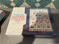 Photo of new unopened Lori Holt Bee Happy Quilt 1000 piece puzzle box showing quilt-themed artwork on the cover.