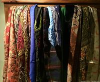 Front view of 11 scarves draped showing various patterns and colors including floral, animal print, solid colors, and plaid.