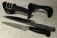 Photo showing two kitchen knives and two knife sharpeners on countertop.