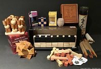 Photo showing entire set of wooden games and puzzles arranged together including Four in a Row game, Star Puzzle box, pick-up sticks container and wooden puzzle pieces.