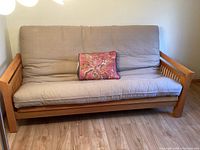 Front view of futon couch with cushion and pillow