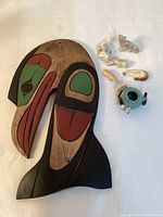 Image showing wood carved Alaskan fish alongside five tiny carved Alaskan animals and a small turquoise-speckled pottery bowl.