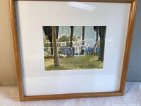 Framed watercolor painting displayed on table against wall