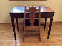 Desk and chair set from rear view showing chair backrest and desk folded down.