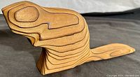 Side view showing the beaver's head and layered wood grain detail