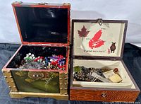 Two wooden jewelry boxes open side by side full of various bead necklaces and costume jewelry items