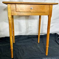 Front view of country pine night stand showing drawer and turned legs