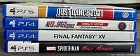 Stacked image of four game cases showing titles for PS4 and PS5 games Just Dance 2021, Need for Speed Rivals, Final Fantasy XV, and Marvel Spider-Man Miles Morales.