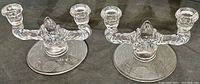 Pair of clear cut crystal double-arm candlestands with corn flower decoration, viewed from front angle, showing detailed floral cuts.