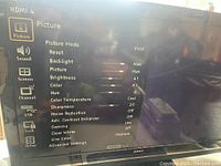 TV screen showing on-screen picture settings menu with HDMI 4 input selected. TV is powered on and menus are displayed, indicating it is working.