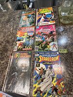 Top view of six vintage comic books laid out on a surface, titles visible