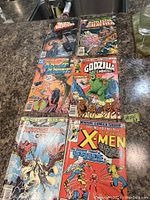 Photo showing all six vintage comic books laid out on a surface.