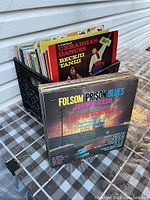 Photo of a box of assorted vinyl records including a Ukrainian dances album and Johnny Cash's Folsom Prison Blues.