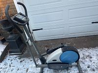 Full view of the elliptical trainer showing frame, handlebars, foot pedals, and control panel