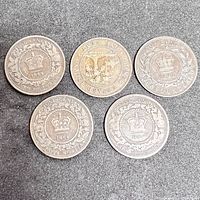 Five Canadian one cent coins arranged flat showing reverse side with crowns, denomination and region, dates including 1864, 1866, 1880