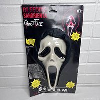 Front image showing the vintage 1997 SCREAM Bleeding Sangrienta Ghost Face Halloween mask in sealed original packaging with clear plastic cover. Mask features white ghost face, black hollow eyes and mouth, with a black fabric hood attached.