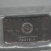 Obverse side of sealed silver bar showing markings and serial number.