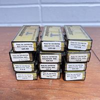 Photo showing 11 vintage Recotron record needle boxes stacked in 3 columns, each box labeled with 'Keep for reordering RECOTON NO.' and model number.