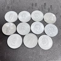 Overview of 11 silver-tone commemorative coins laid out in 3 rows showing various prime minister portraits.