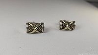 Front view of pair cufflinks showing twisted cables and 14k gold 'X' overlay
