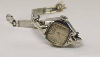 Close-up photo of vintage ladies wristwatch showing stainless steel case, applied numerals, and original crown.