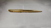 Full length side view of gold tone Parker ballpoint pen on white background