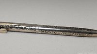Side view of the engraved sterling silver mechanical pencil with floral scroll design