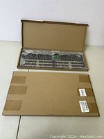 Two flat metal decor plates inside cardboard packaging, one visible with cutout airplane shapes and text.