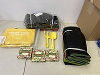 Full lot image showing yellow bag, small yellow garden fork and spade, seed packets, and rolled garden mat.