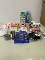 Full view of lot showing various items including false eyelashes, mascara, eyeliner, adhesive pads, and hairbands on a flat surface.
