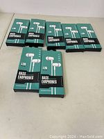 Seven boxed L29 Bass Earphones in a row on a white surface.