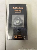 Box packaging of the multifunctional headlamp with brand name, product features such as magnet adsorption and USB Type-C interface visible.