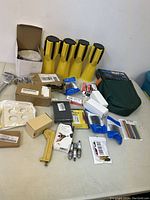 Overview photo showing flashlights, spark plugs, hand tools, and assorted small automotive parts on a table.