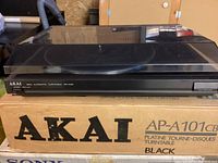 Side angle of Akai AP-A101 turntable on original box showing front panel and branding.