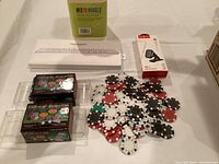 Photo showing two boxed sets of poker chips, Apple's Magic Keyboard in a white box, and a magnetic car phone holder in retail packaging.