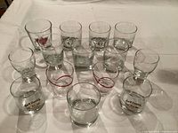 Eighteen assorted glasses arranged on surface with some branded Jack Daniel's and 40 oz. whiskey glasses visible.