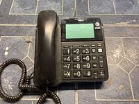 Black AT&T corded desk phone with handset and digital display showing AT&T logo.