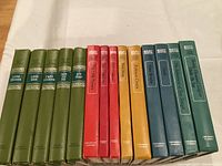 Photo of 14 hardcover children's classic books in various colored cloth bindings arranged by color.
