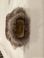 Top-down view showing the opening of the furry cover revealing the hot water bottle's neck and cap.