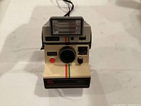 Front view of Polaroid Land Camera Sears Special showing the Q-Light flash mounted on top, camera lens, and control buttons.